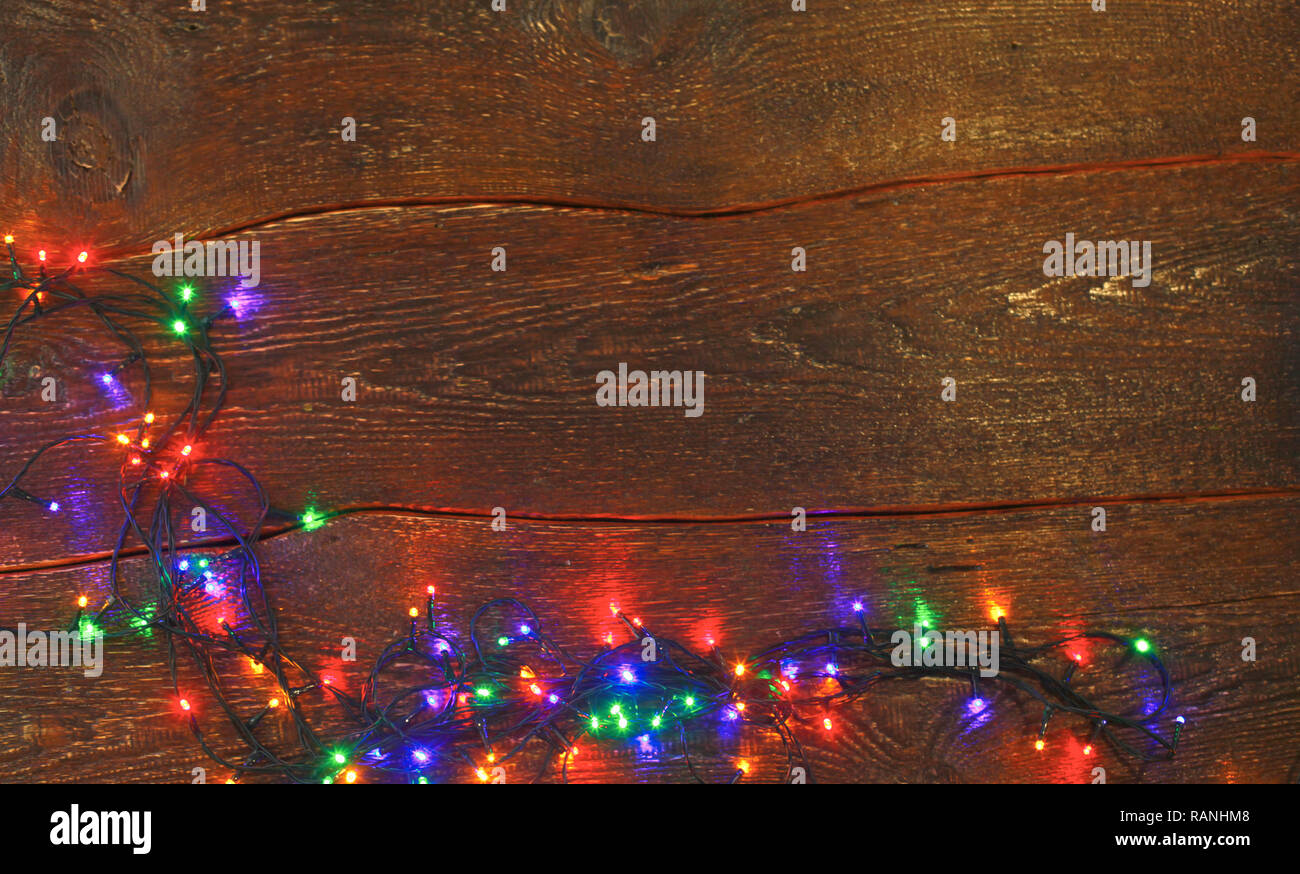 Christmas lights on a wooden background. View from above Stock Photo