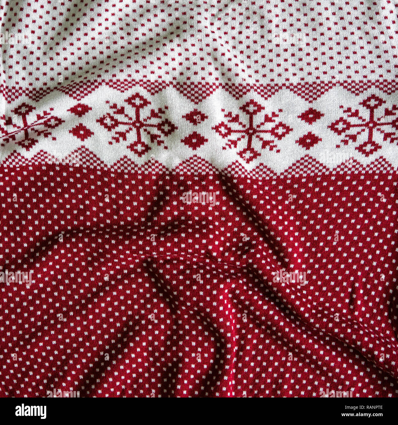Knitted woolen background. white and red knitted Norwegian pattern. Stock Photo