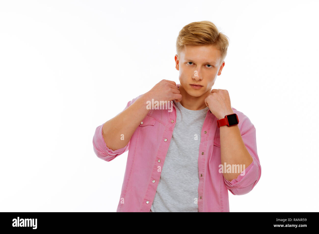 Serious nice young man touching his collar Stock Photo