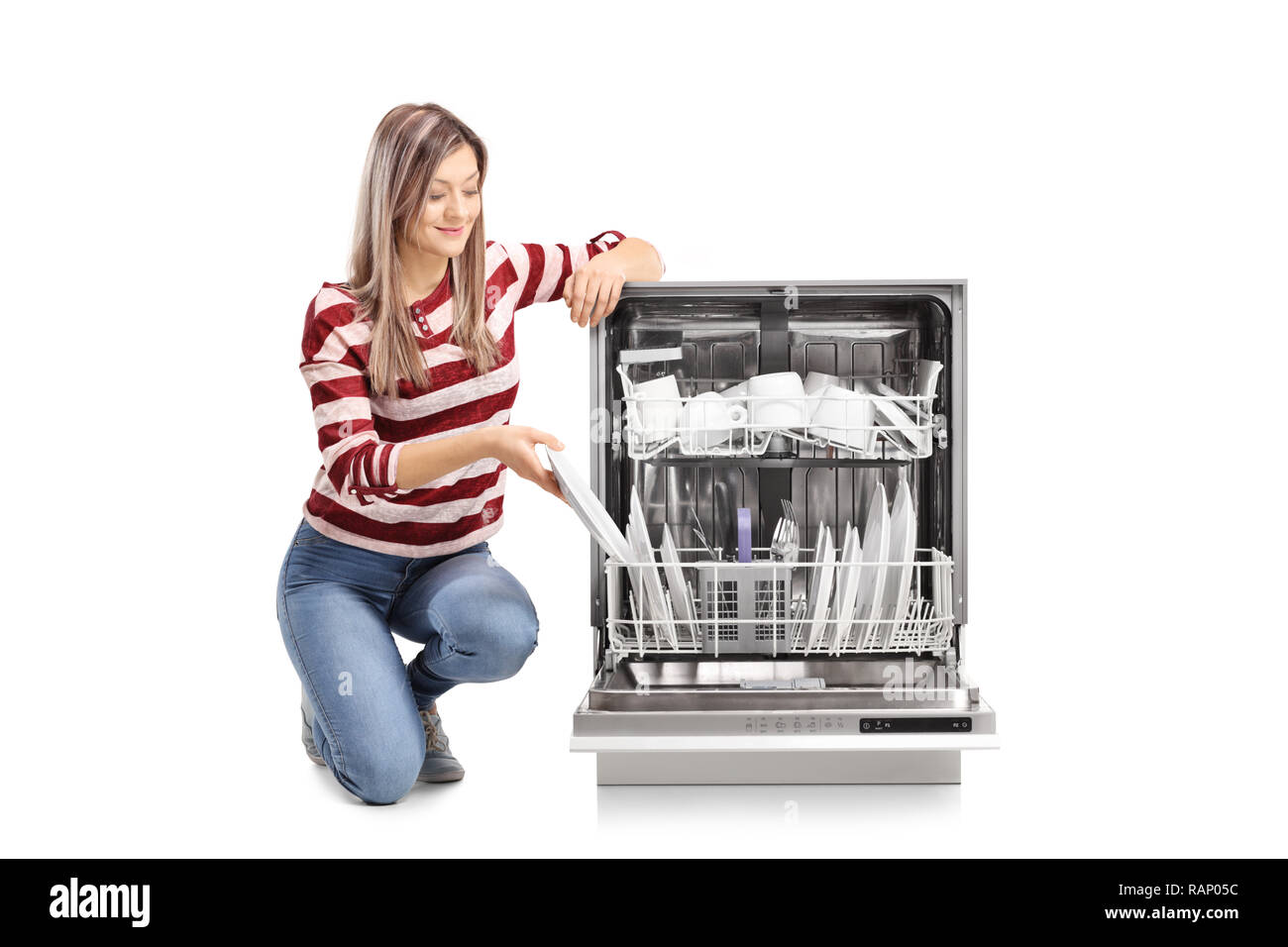 Beautiful young woman putting a plate into a dishwasher isolated on white background Stock Photo