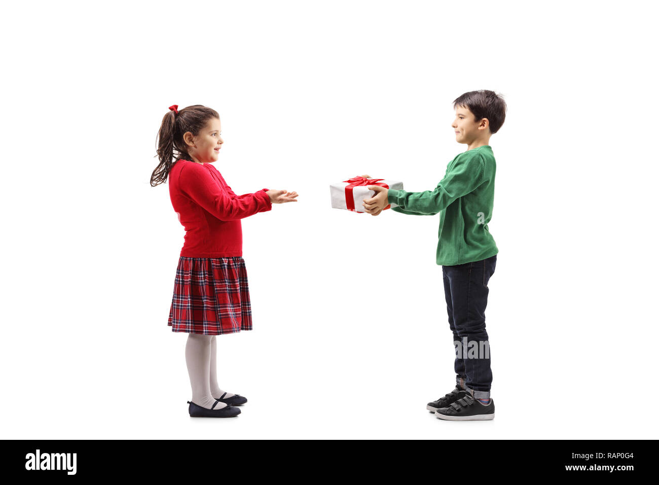 Full length shot of a little boy giving a wrapped present to a little girl isolated on white background Stock Photo