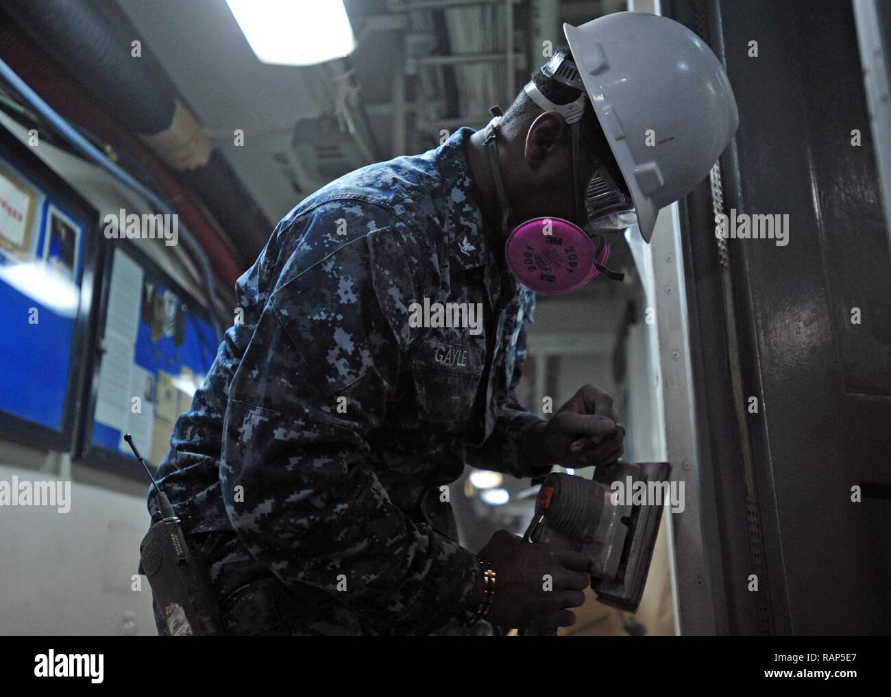 YOKOSUKA, Japan (Feb. 22, 2017) - Hospital Corpsman 3rd Class Patrick Gayle from Jacksonville, Fla., attached to the U.S. 7th Fleet flagship USS Blue Ridge (LCC 19), sands a door frame in the ship's medical waiting area. Blue Ridge is in an extensive maintenance period in order to modernize the ship to continue to serve as a robust communications platform in the U.S. 7th Fleet area of operations. Stock Photo