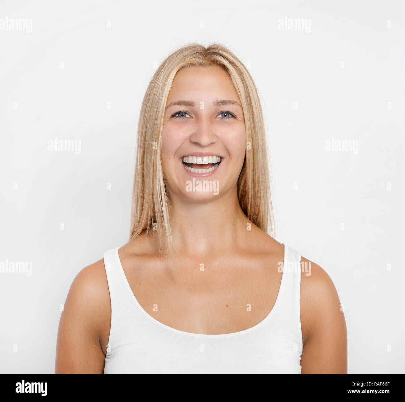 a young blond woman with blue eyes laughs at the camera, white background, isolated Stock Photo
