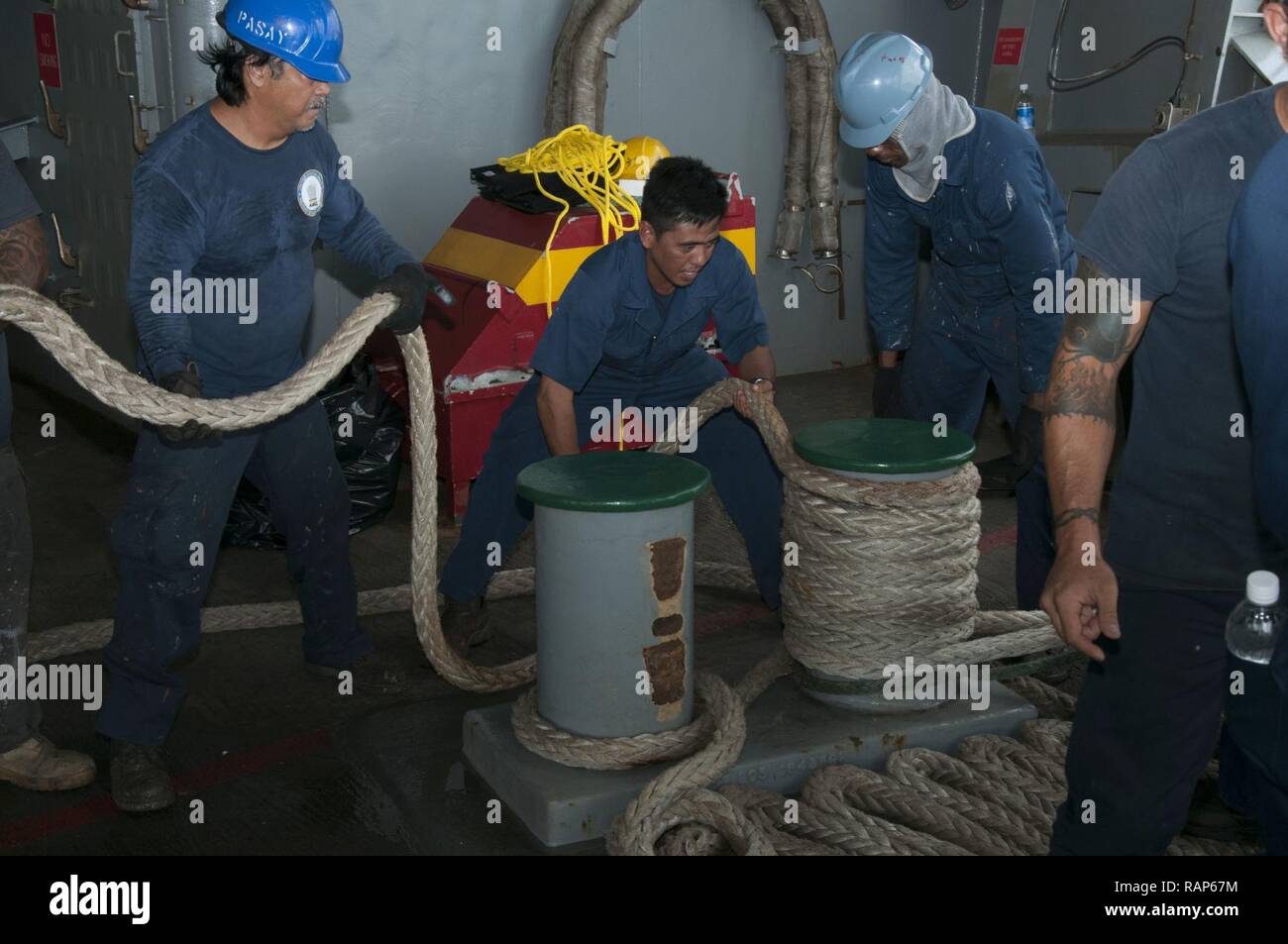 POLARIS POINT, Guam (Feb. 23, 2017) Military Sealift Command deck department, assigned to the submarine tender USS Frank Cable (AS 40), secure mooring lines after the ship shifted to Bravo Pier at Polaris Point, Guam, Feb. 23.  Frank Cable is forward deployed to the island of Guam and conducts maintenance and support of submarines and surface vessels deployed to the U.S. 5th and 7th Fleet area of operations. Stock Photo