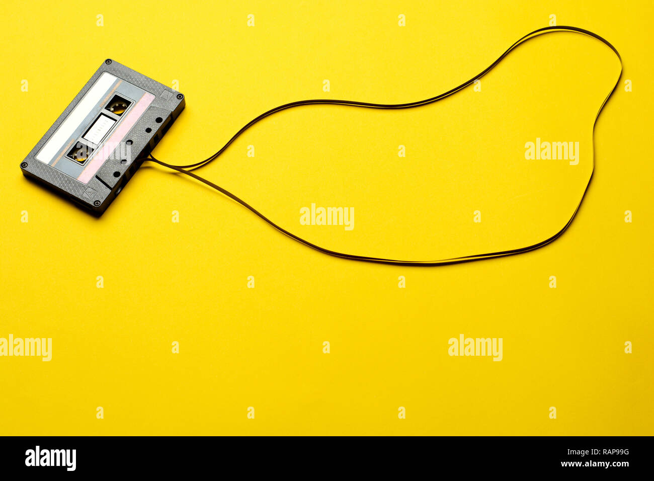 Retro cassette with tape over yellow table background. top view. copy space Stock Photo