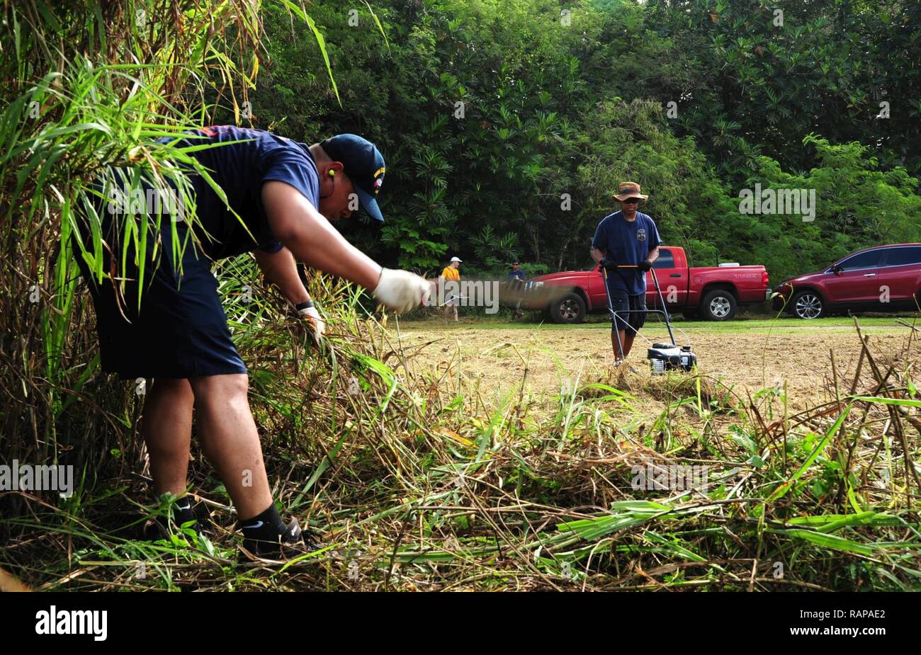 PITI, Guam (Feb. 25, 2017) – Boatswain’s Mate 1st Class Francisco Fuenteshernandez, native of Elmhurst, N.Y., and Master Chief Machinist’s Mate David Ford, native of Belcher, La., both assigned to the submarine tender USS frank Cable (AS 40), cut the grass around the Atantano Shrine in Piti, Guam Feb. 25, during a CPO 365 community relations project.  Frank Cable is forward deployed to the island of Guam and conducts maintenance and support of submarines and surface vessels deployed to the U.S. 5th and 7th Fleet area of operations. Stock Photo