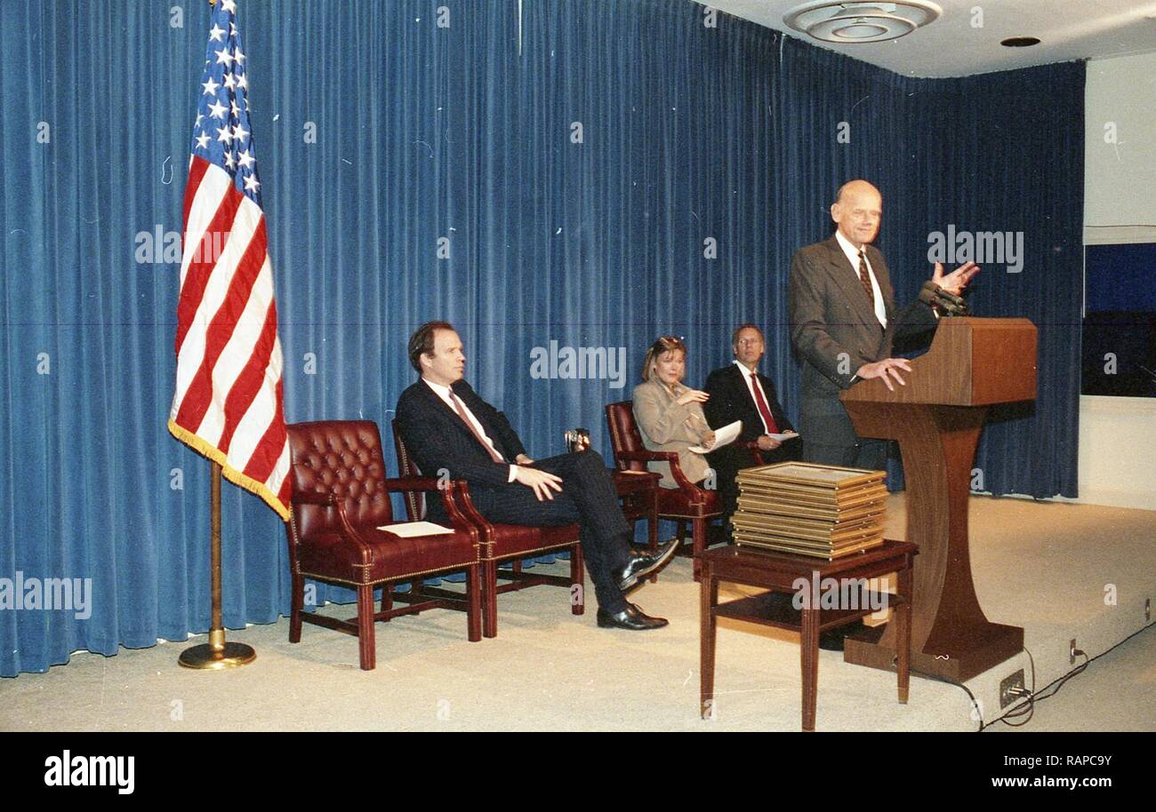 A MAN AT THE PODIUM GIVING A SPEECH WITH OTHER PEOPLE WATCHING Stock ...