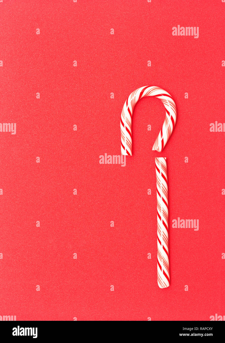 Broken candy cane on red background Stock Photo - Alamy