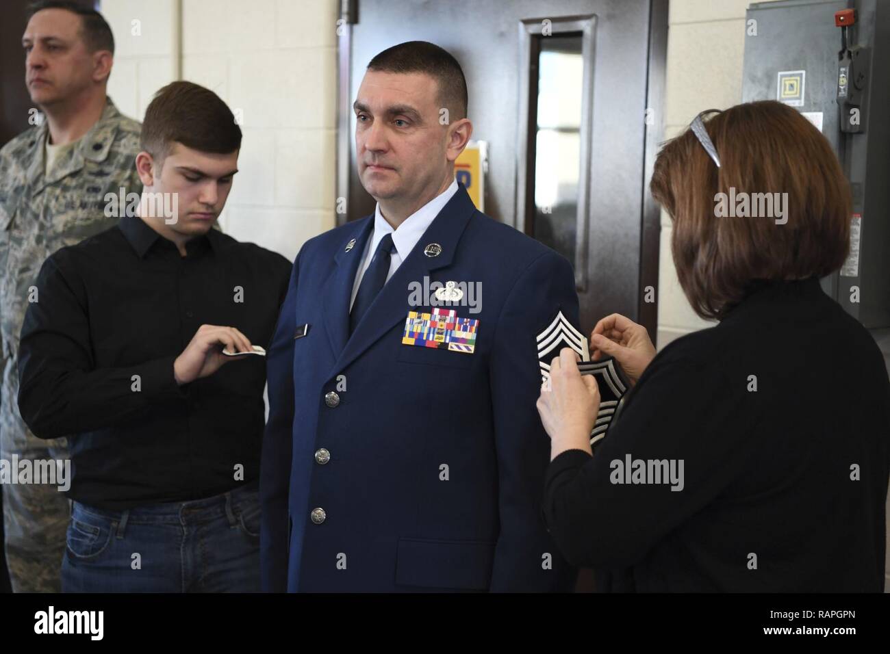 Chief Master Sgt Mike Powell 130th Airlift Wing Communications Flight Chief Enlisted Manager Stands At Attention While Members Of His Family Pin On His New Rank Of Chief Master Sergeant March 4