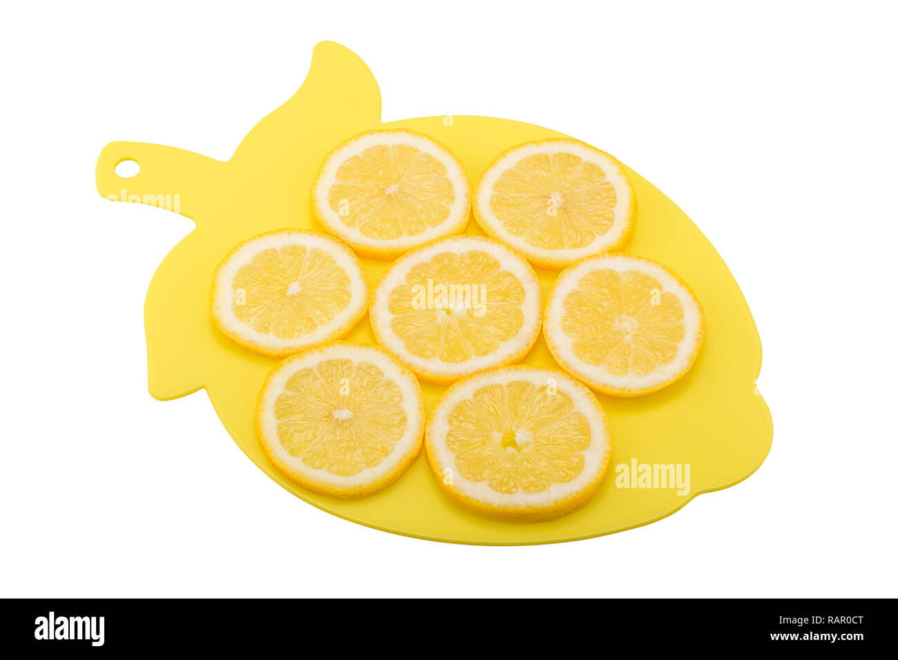 Lemon slices lying on plastic chopping board Stock Photo