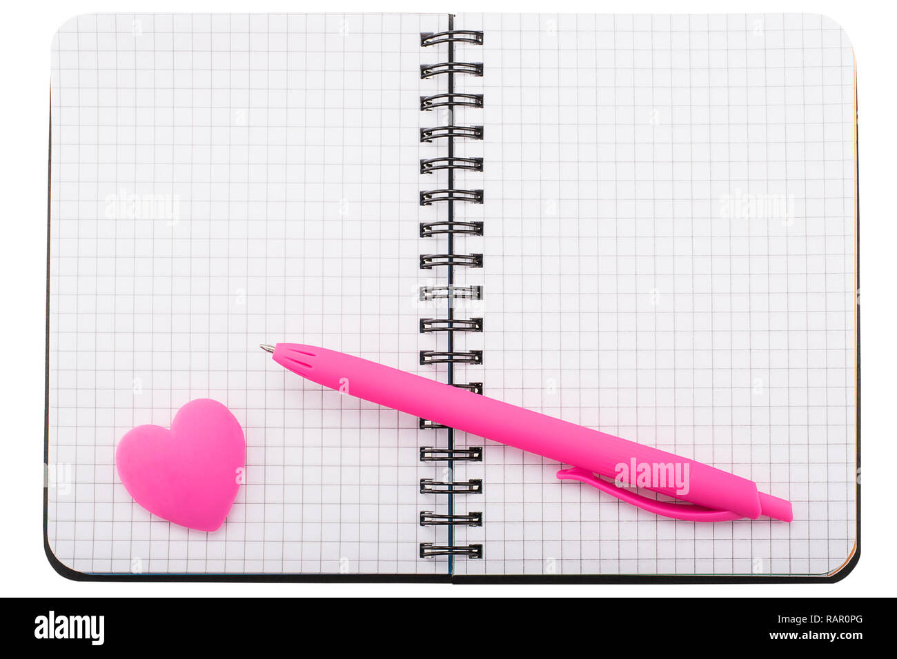 Open spiral squared notebook with ballpoint pen and heart shaped eraser Stock Photo