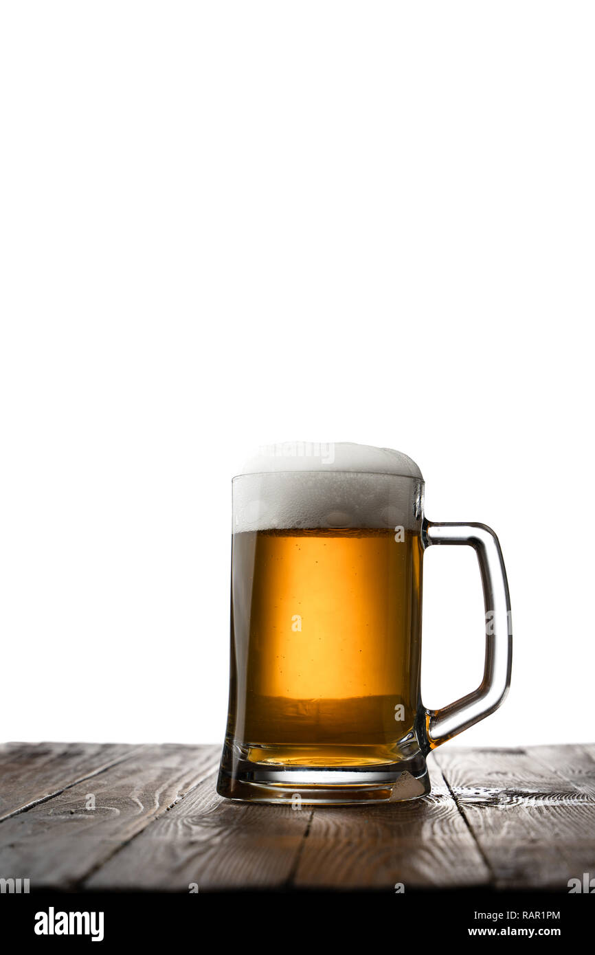 Frosted mug of light beer on wood table and white background behind