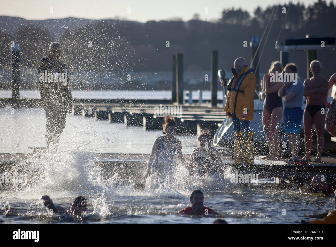 Swimmers jumping into the water a the New Years Day Swim at Rhur Marina, Scotland. Stock Photo