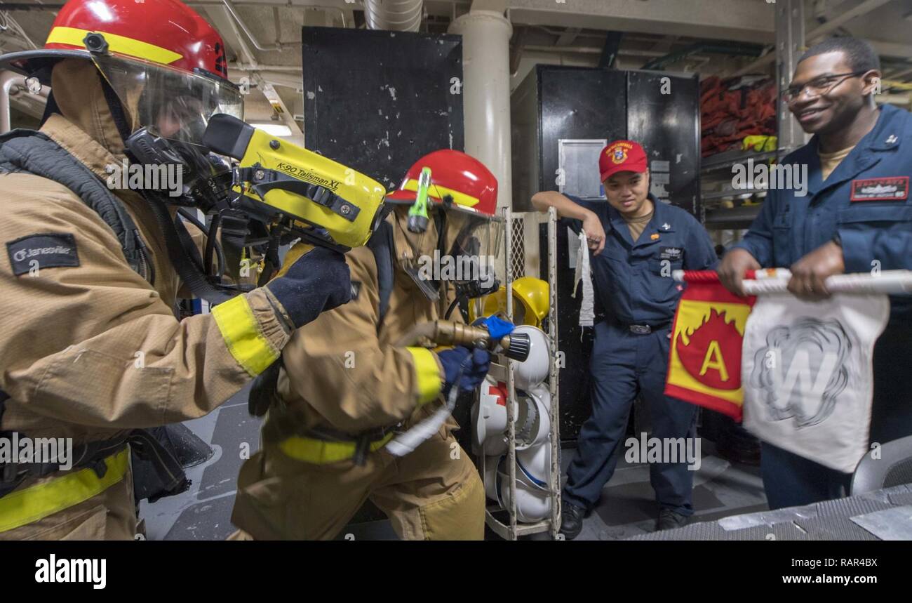 EAST CHINA SEA (Dec. 10, 2018) The damage control team fights a simulated fire during an exercise aboard the Arleigh Burke-class guided-missile destroyer USS McCampbell (DDG 85). McCampbell is forward-deployed to the U.S. 7th Fleet area of operations in support of security and stability in the Indo-Pacific region. Stock Photo