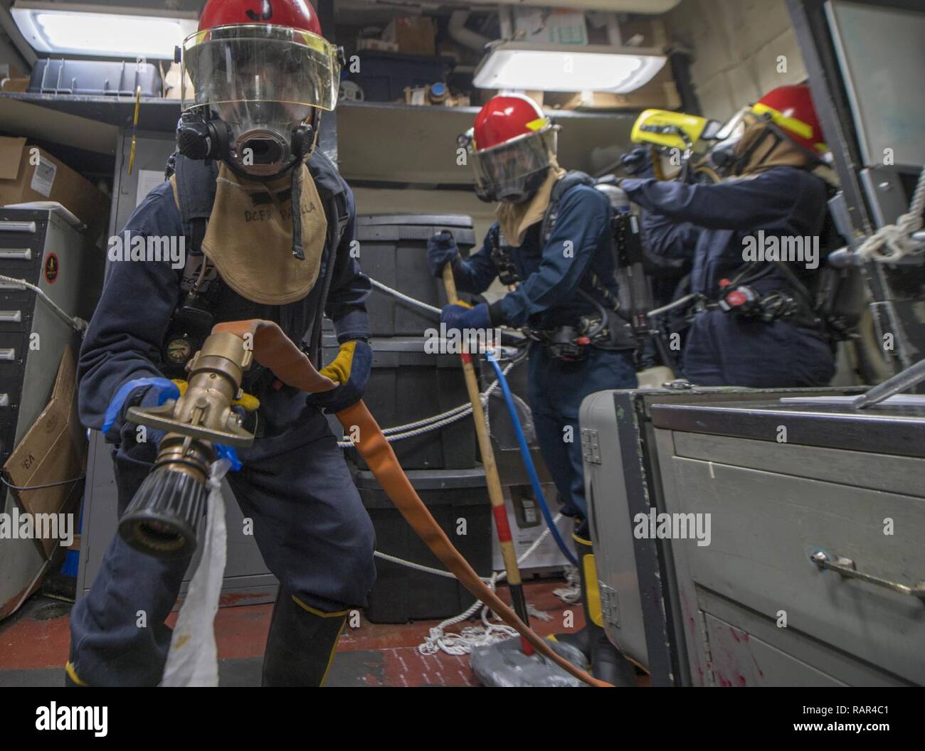 EAST CHINA SEA (Dec. 10, 2018) Damage Controlman Fireman Recruit Johnnie Padilla, from Los Angeles, Cali., left, fights a simulated fire during an exercise aboard the Arleigh Burke-class guided-missile destroyer USS McCampbell (DDG 85). McCampbell is forward-deployed to the U.S. 7th Fleet area of operations in support of security and stability in the Indo-Pacific region. Stock Photo