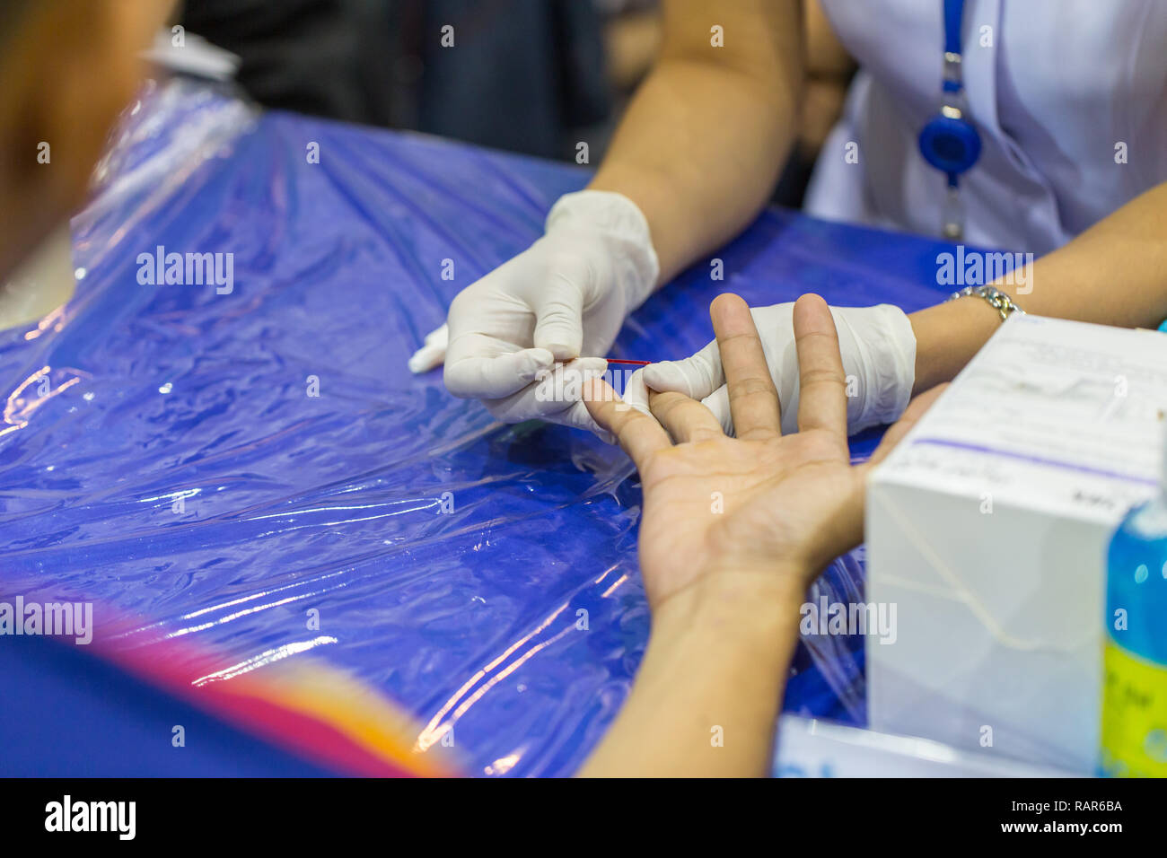 Nurse keep tiny drop of blood sample from fingertip for testing testing