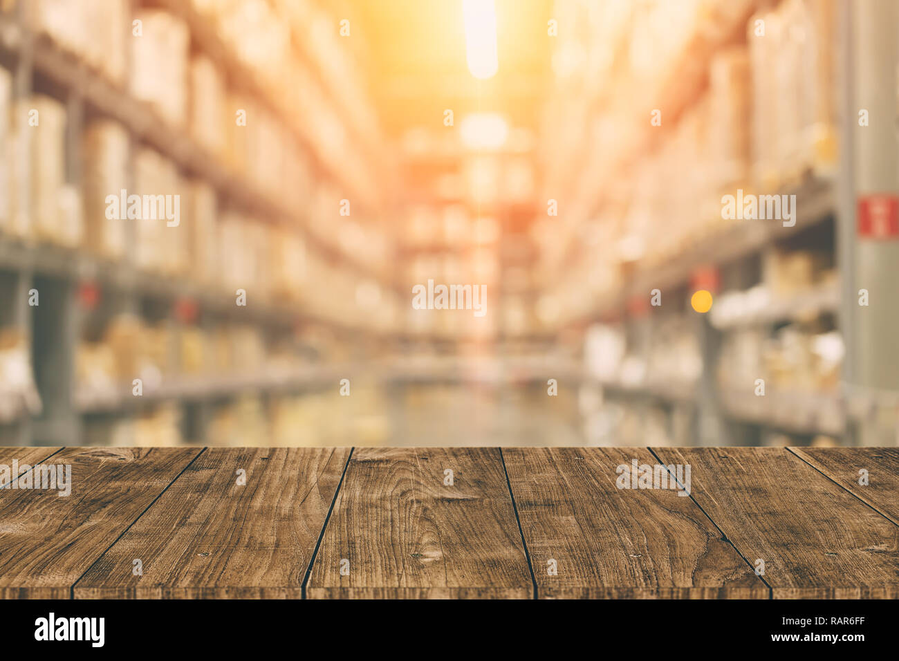 Warehouse inventory in blur for background with empty wooden foreground space. Stock Photo
