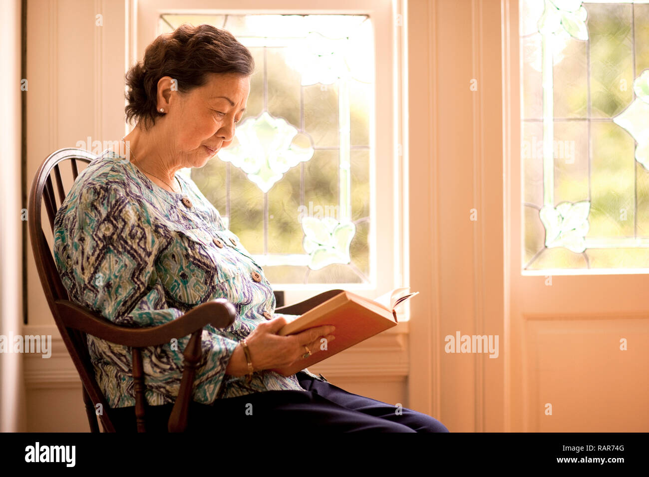 Portrait of senior woman reading a book. Stock Photo