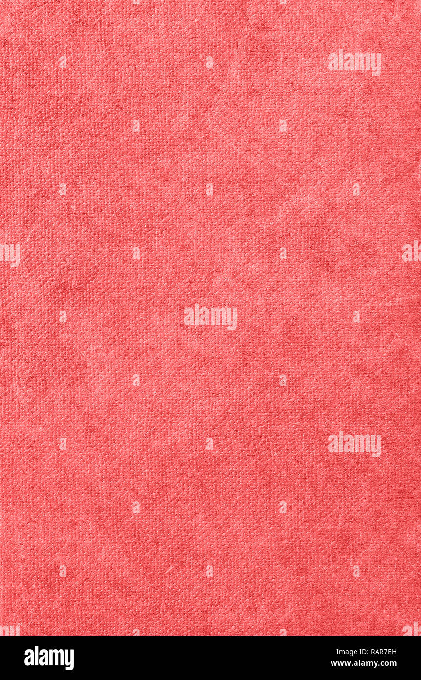 Background texture of old fabric book cover in warm pink coral hue. Stock Photo