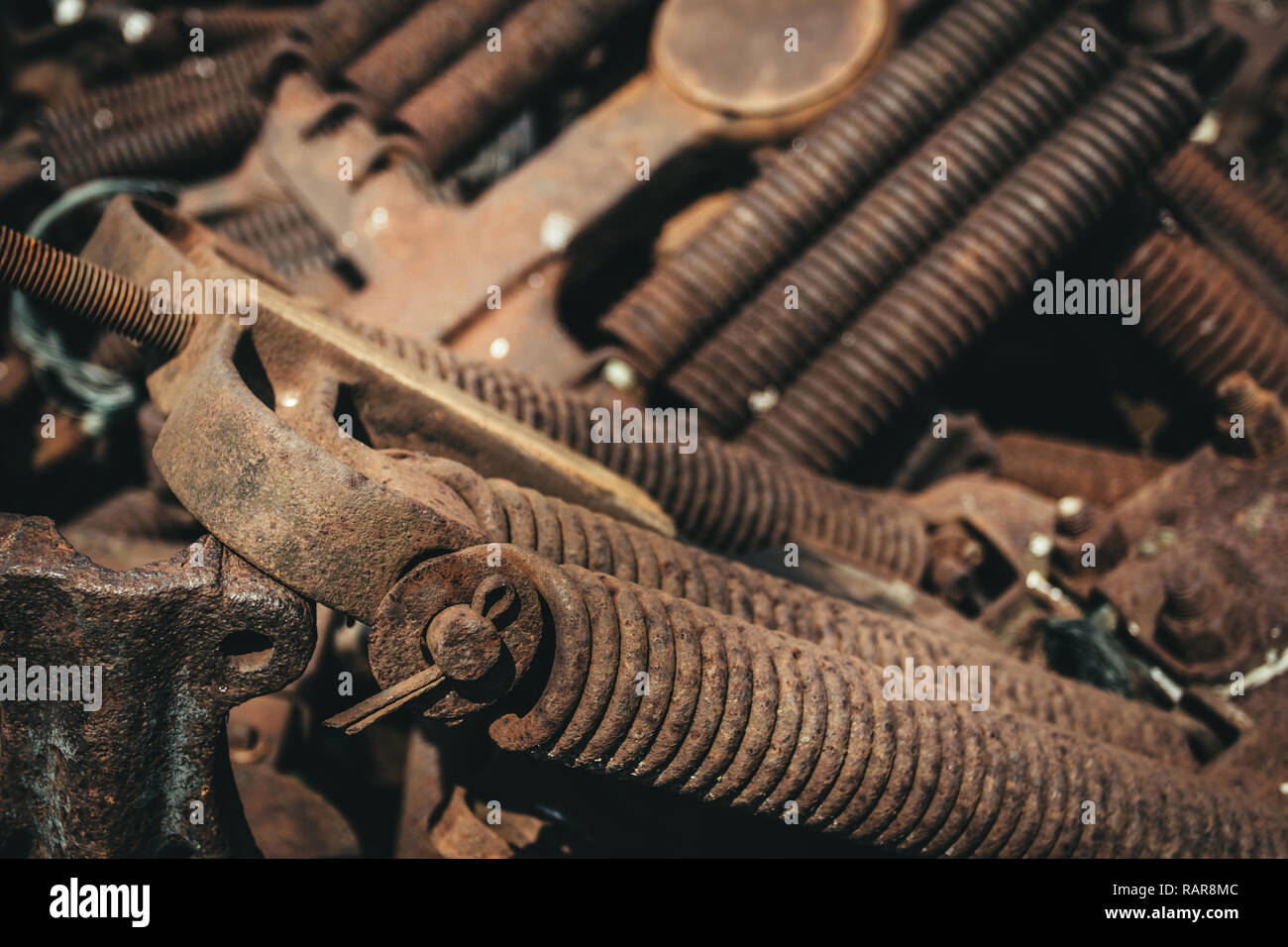 Rusty railroad car spring assemblies laying in a pile on the ground. Stock Photo