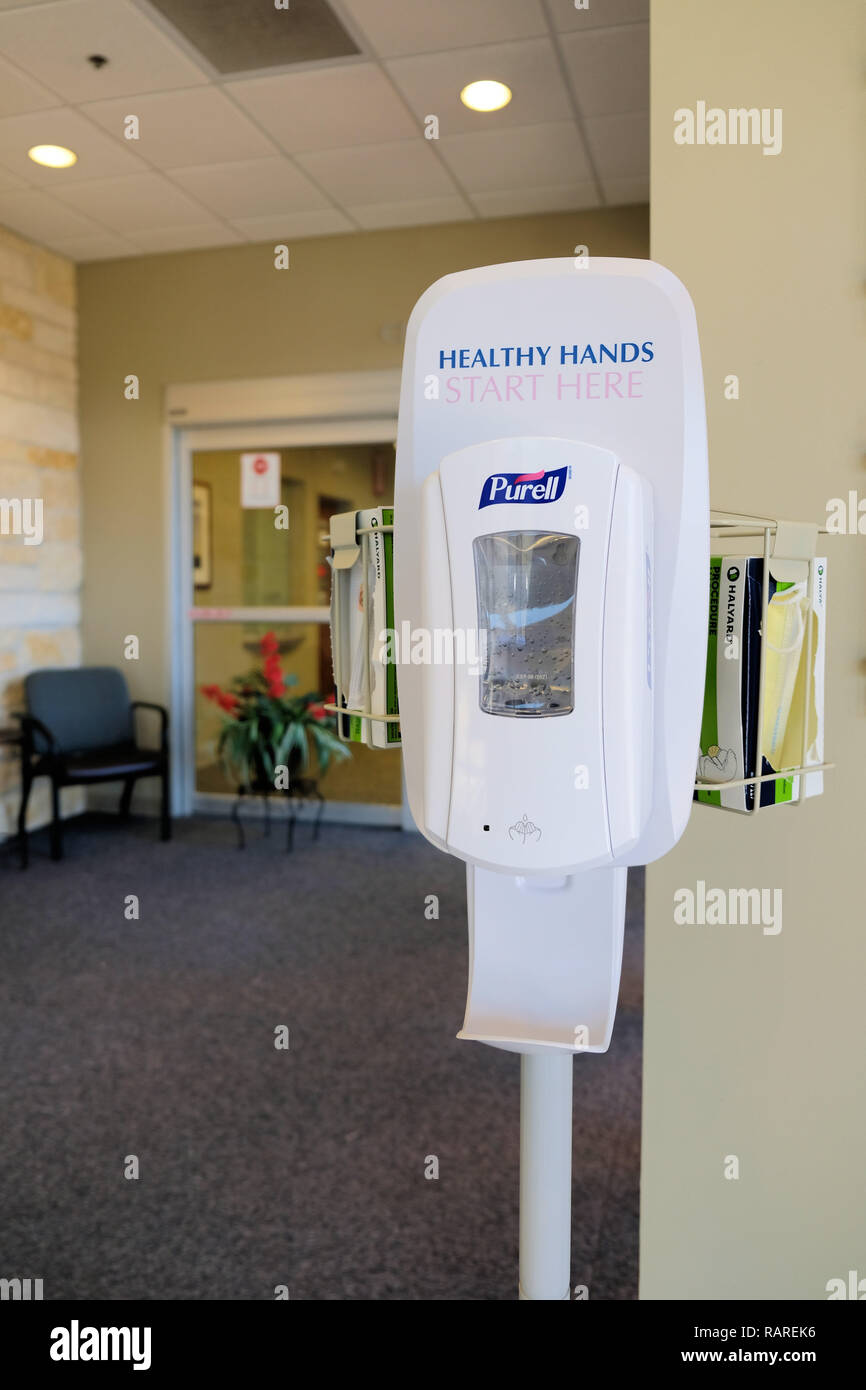 Purell hand sanitizer, antiseptic, and disinfectant dispenser at a medical building lobby; hospital hand sanitizer. Stock Photo