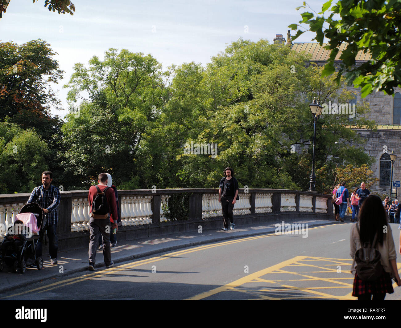 Pedestrians crossing the 'Salmon Weir Bridge'  in Galway City, West Ireland. Stock Photo