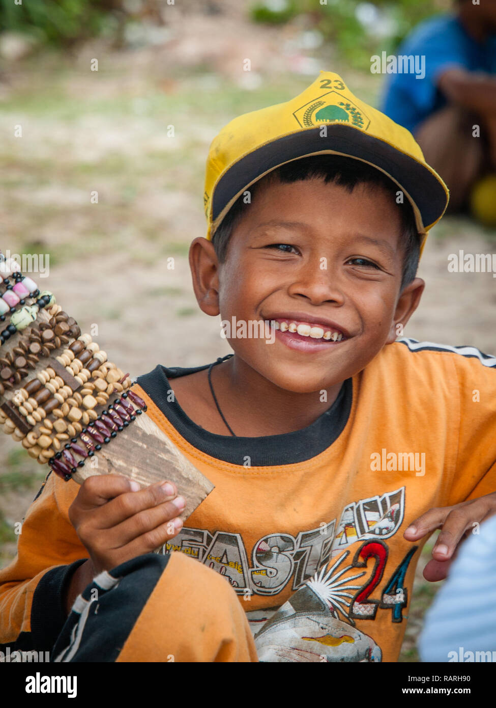 Young Indonesian Asian boy selling handmade bracelet at beach side, Lombok island, Indonesia