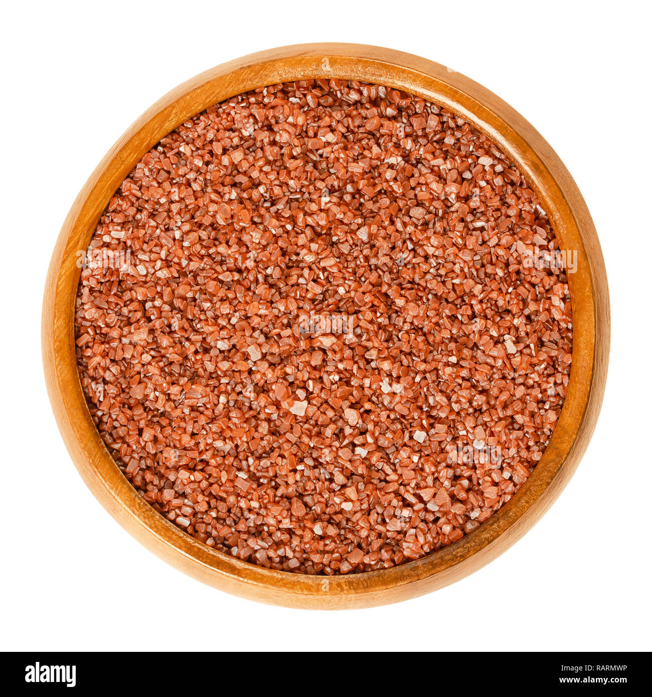 Hawaiian red sea salt in wooden bowl. Alaea salt, unrefined coarse grain, mixed with iron oxide rich volcanic clay. Characteristic brick red color. Stock Photo