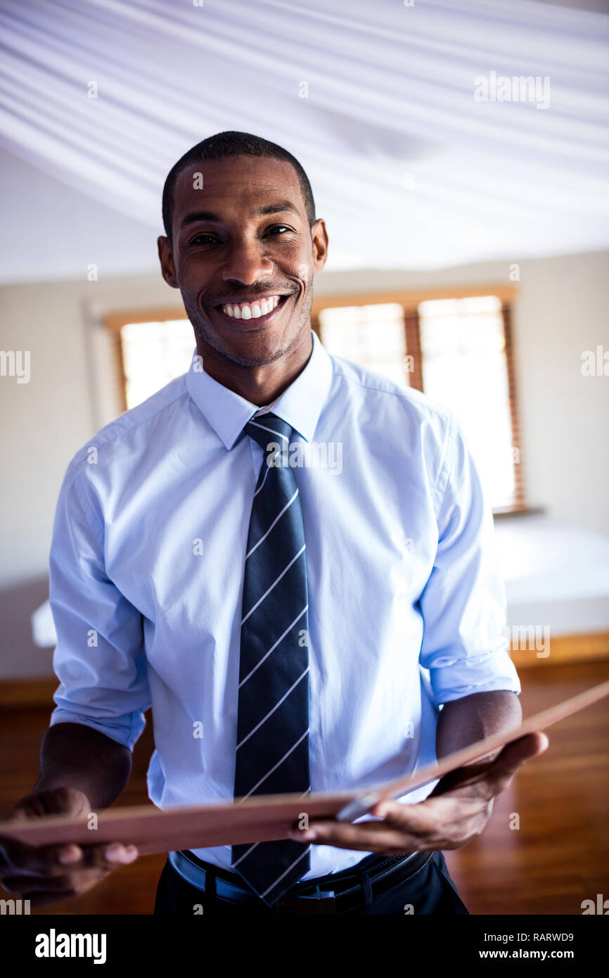 Male supervisor standing with a file in hotel Stock Photo
