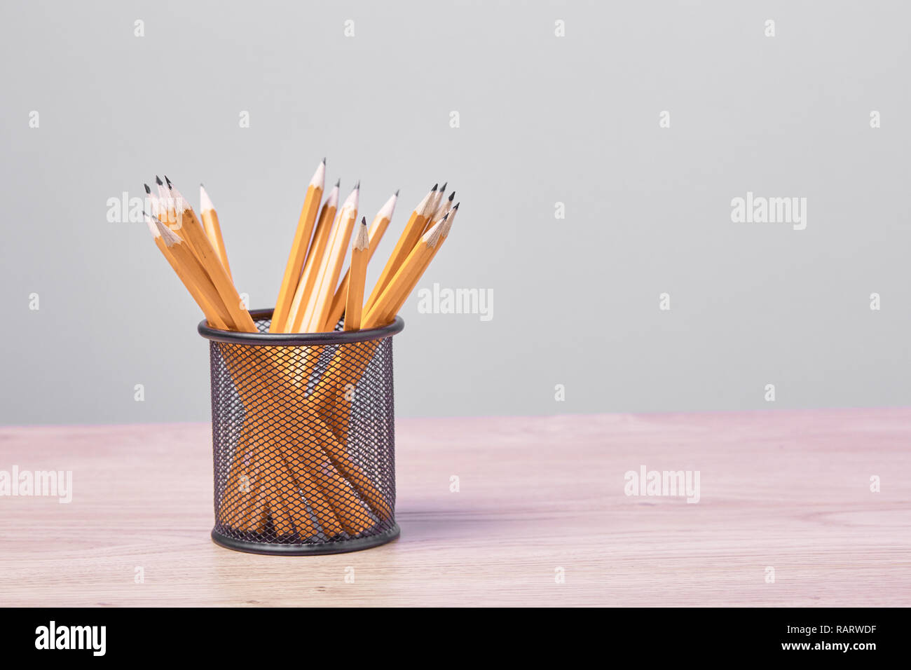 Graphite pencils in a metal grid-container. Concept. Stock Photo