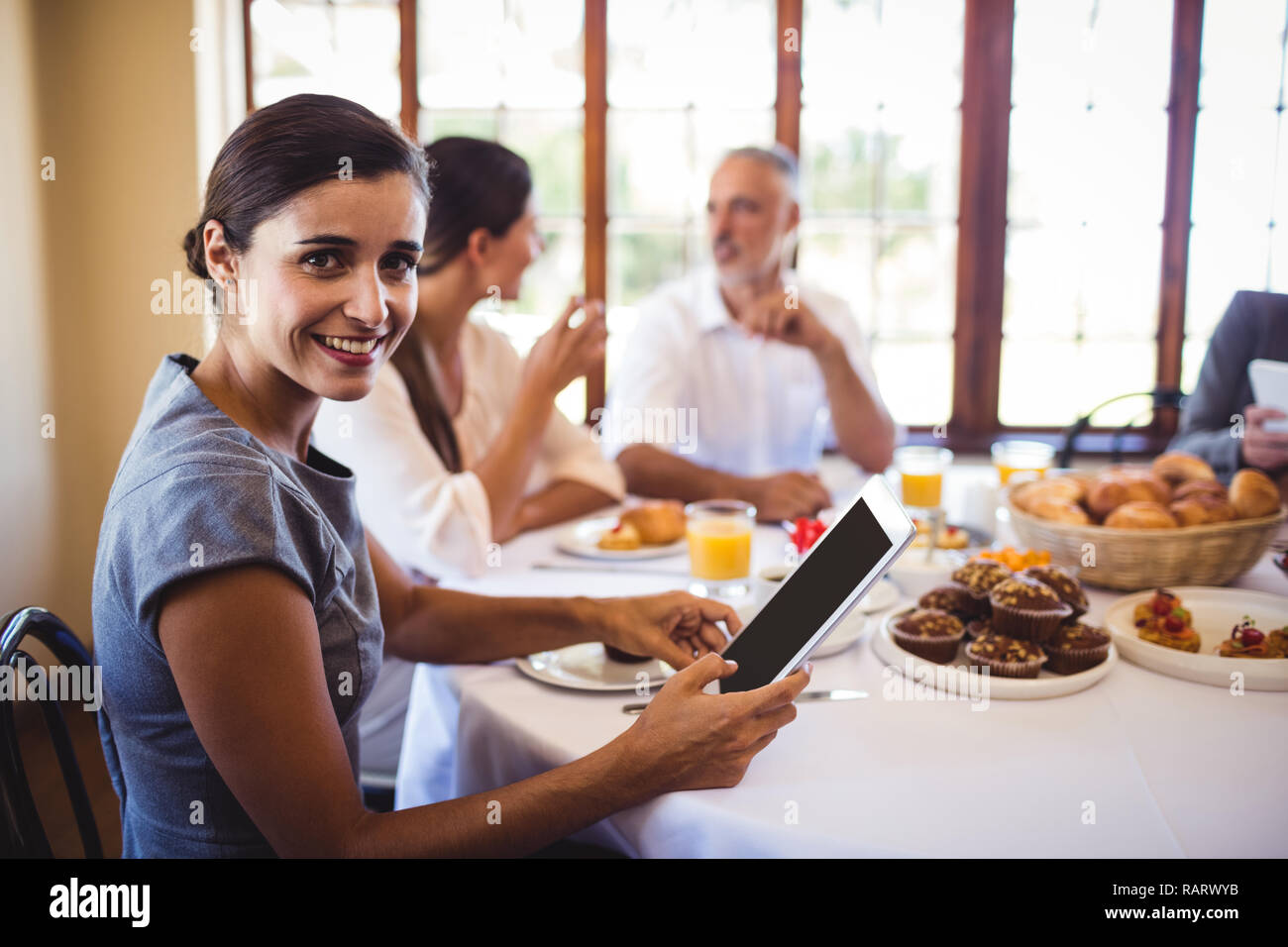Businesswoman looking at camera while using digital tablet Stock Photo