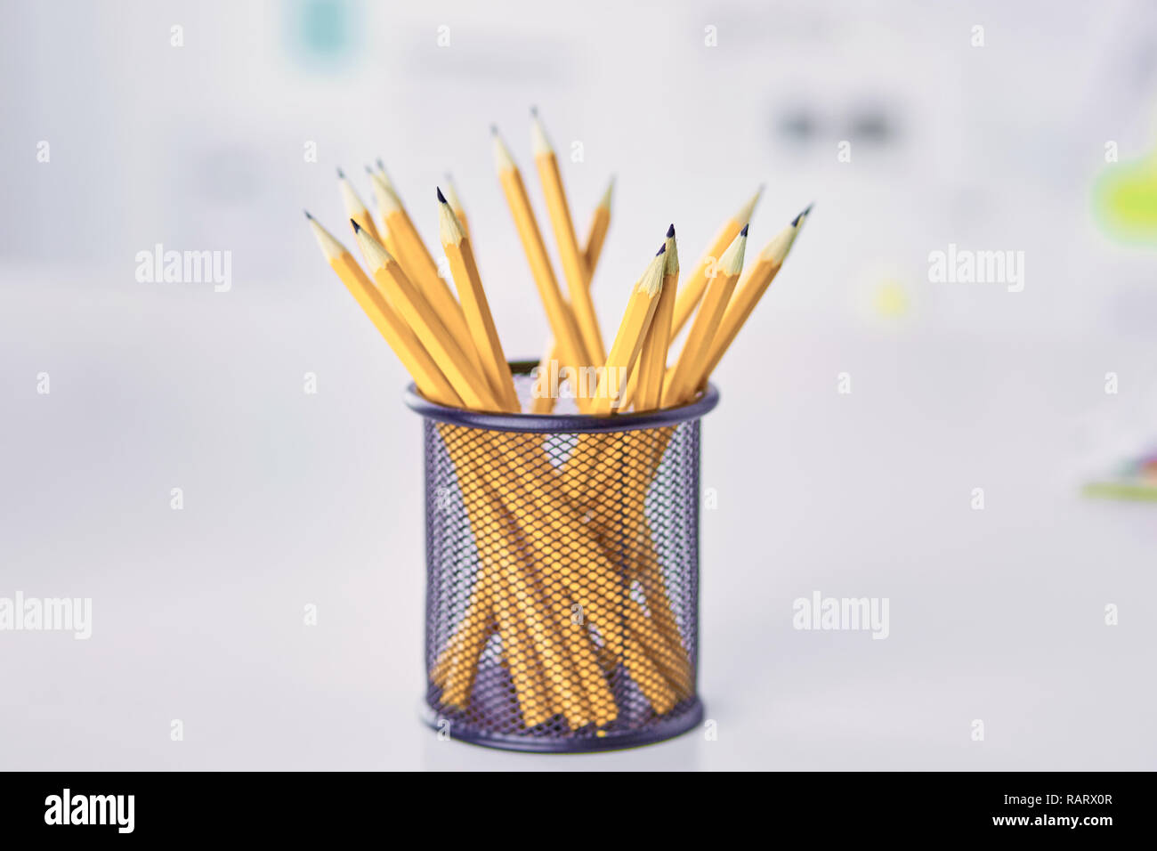 Graphite pencils in a metal gridcontainer on the office table. Concept