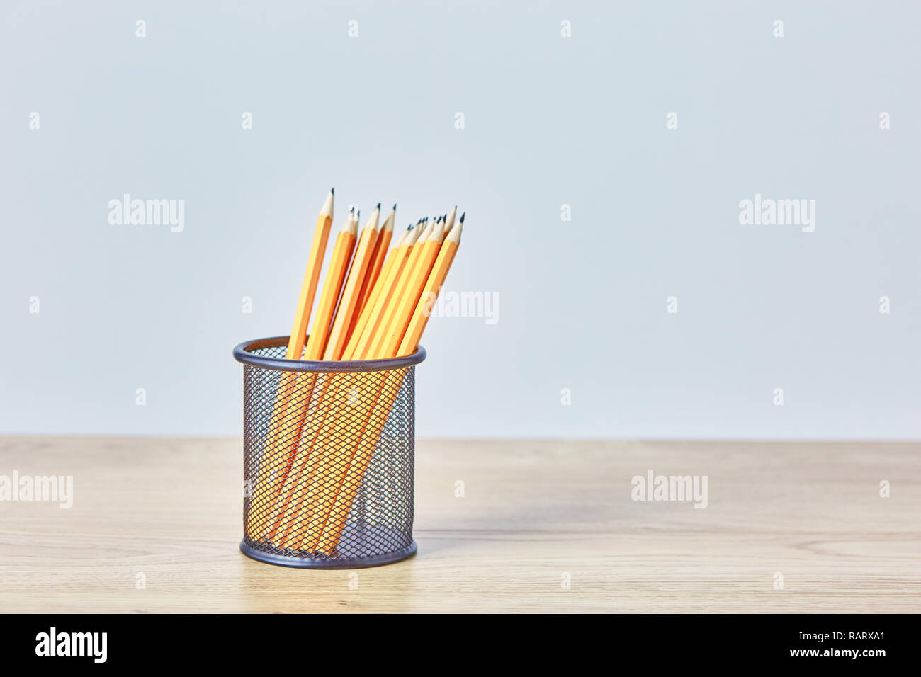 Graphite pencils in a metal grid-container. Concept. Stock Photo