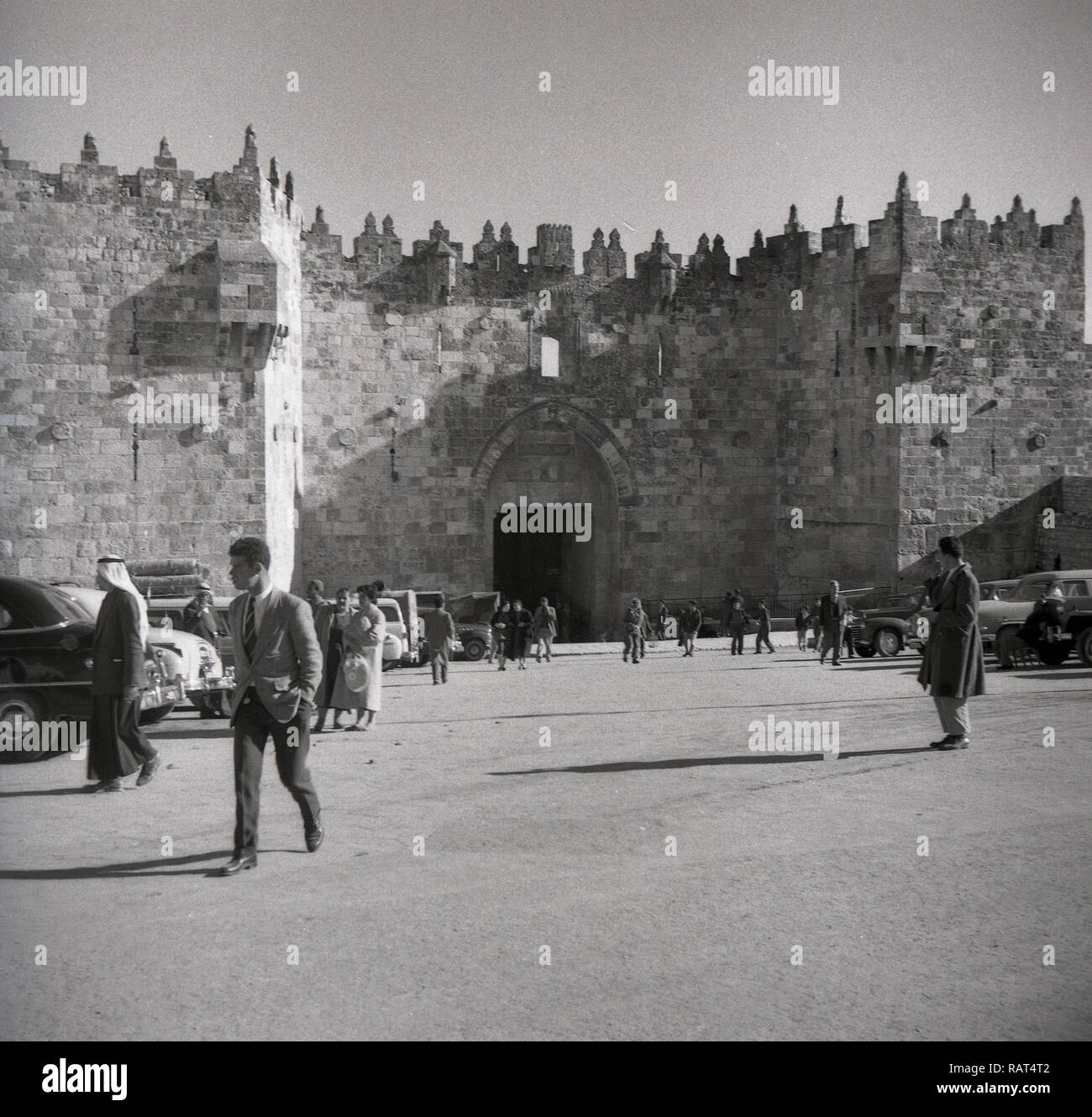 1940s, historical, parked cars and people outside Damascus Gate one of the main entrances to the old holy city of Jerusalem. The gate was built in 1537 under the rule of the Sultan of the Ottoman Empire, repacing an earlier gate from Roman times. Stock Photo