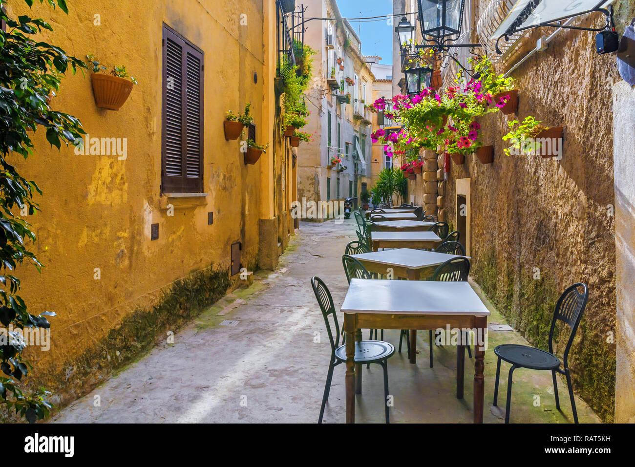Cafe tables and chairs outside in old cozy street in the Positano town, Campania, Italy Stock Photo