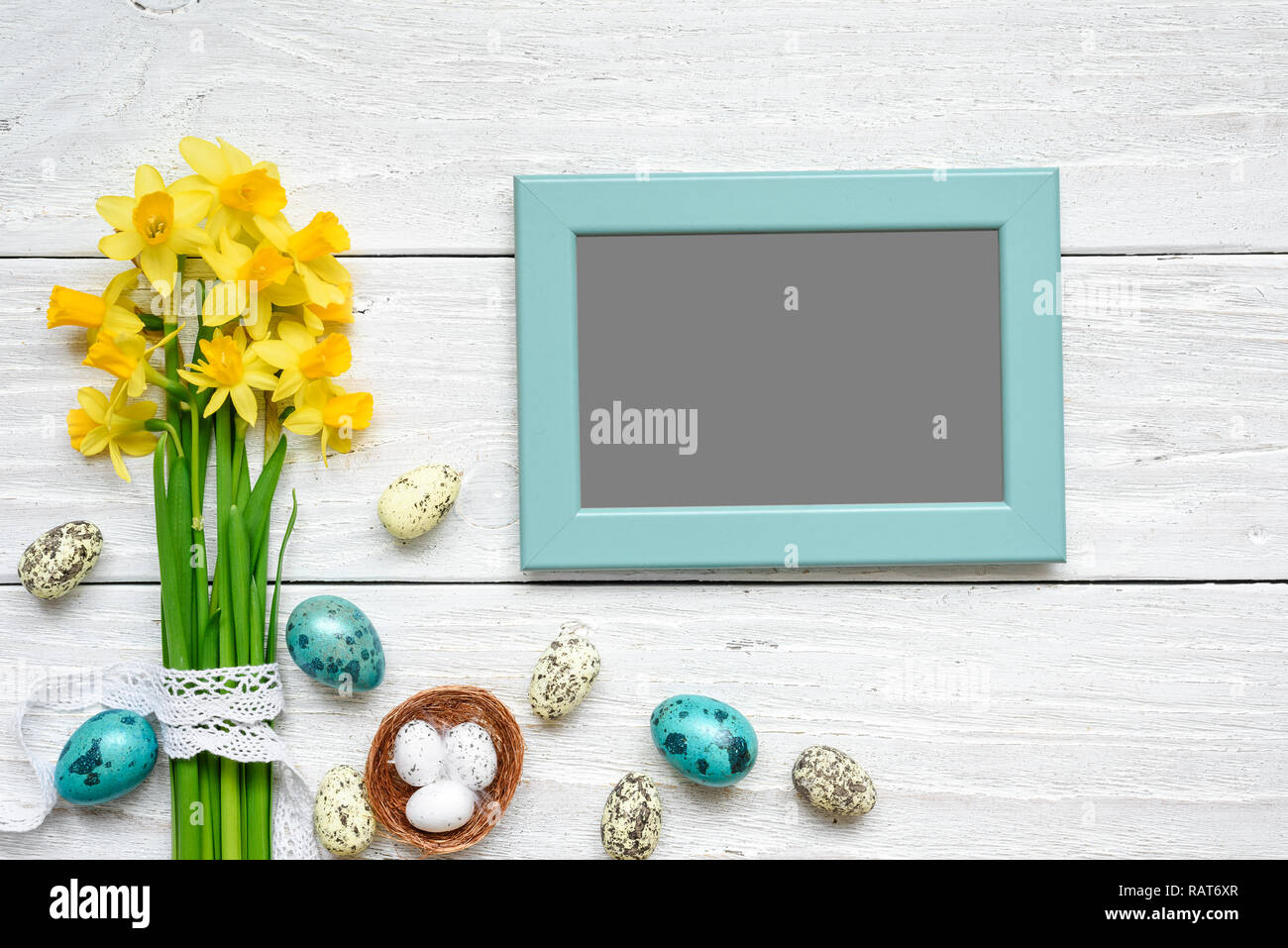 blank photo frame with easter eggs and spring flowers mock up over ...
