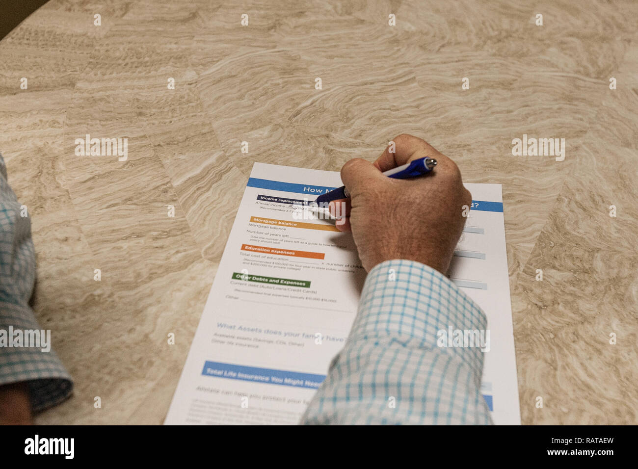 Man With Pen Completing Financial Worksheet Stock Photo