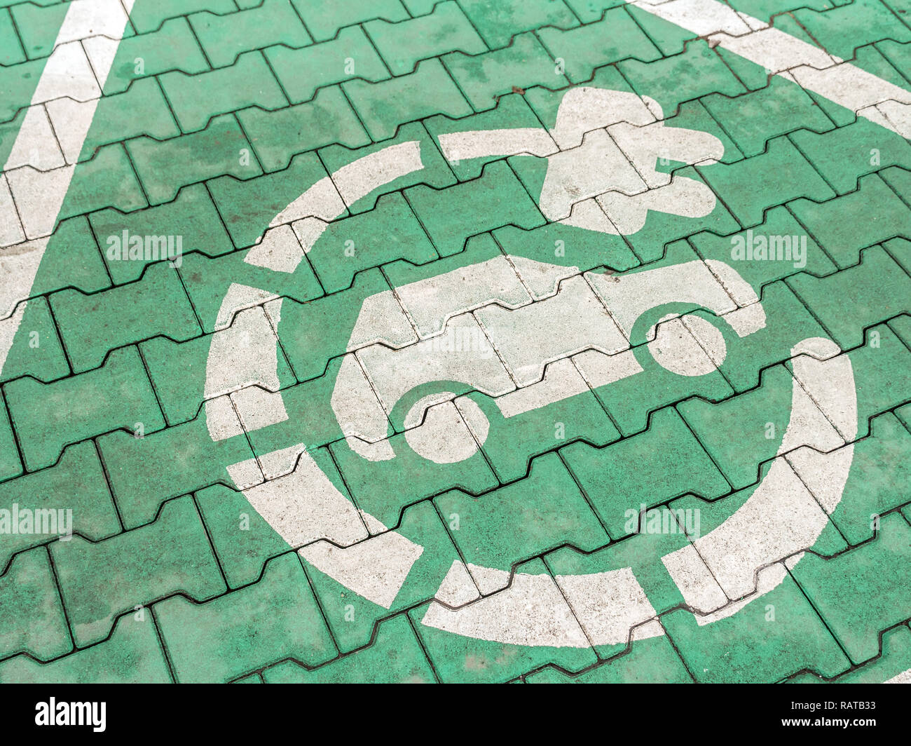 Electric car charging symbol painted on parking lot paving surface Stock Photo