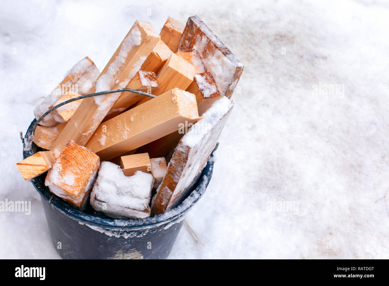 Bucket full of firewood standing on snow. Closeup Stock Photo Alamy
