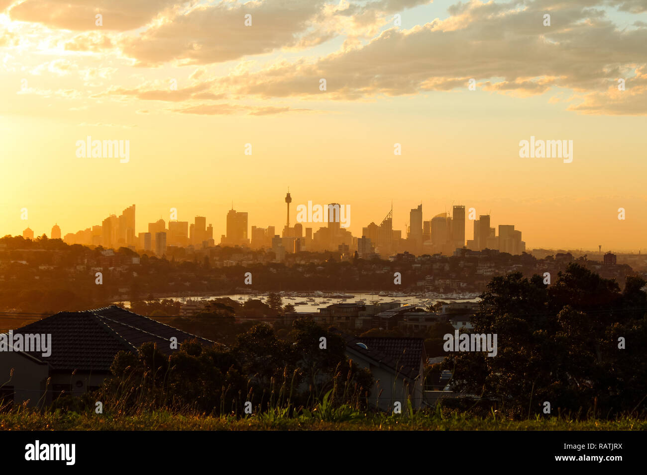 Magical glowing orange sunset over the skyline of Sydney as seen on a