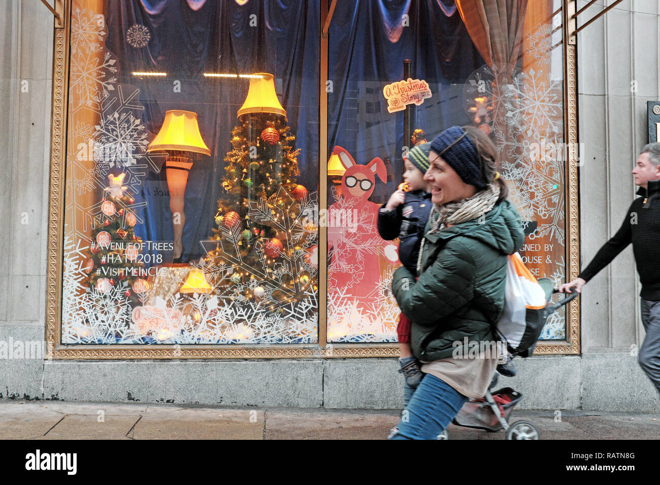 People walk past a holiday window displaying iconic props representing 'A Christmas Story' in downtown Cleveland, Ohio, USA. Stock Photo