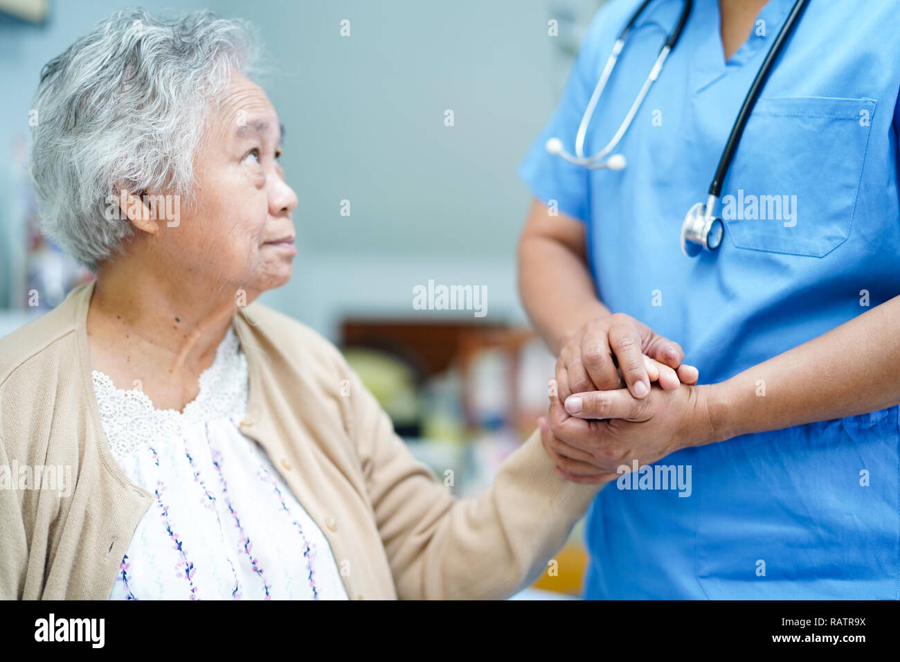 Holding Touching hands Asian senior or elderly old lady woman patient with love, care, helping, encourage and empathy at nursing hospital ward. Stock Photo