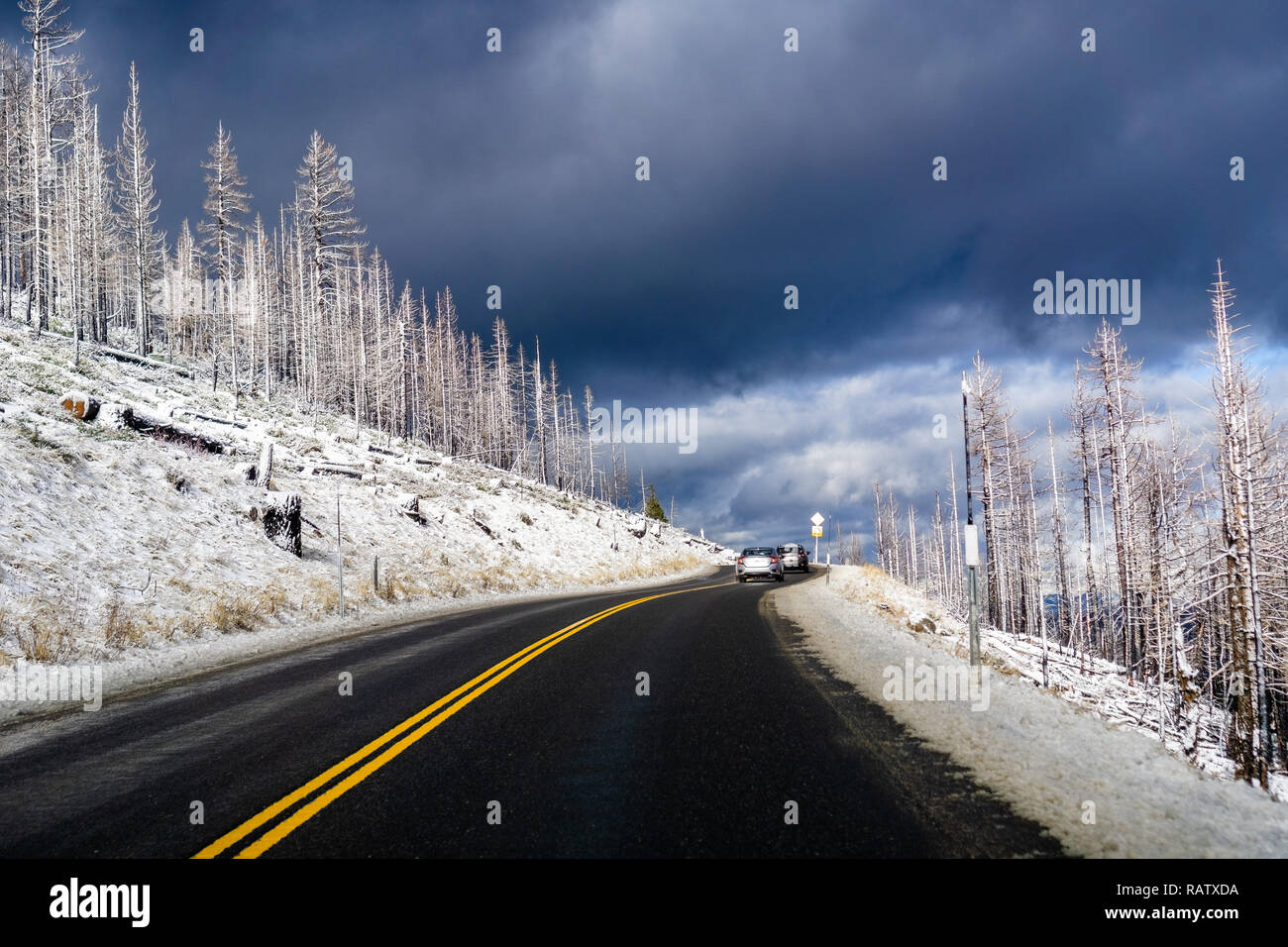 Driving through Sierra Mountains, close to Lake Tahoe on a winter day; menacing storm clouds background; California Stock Photo