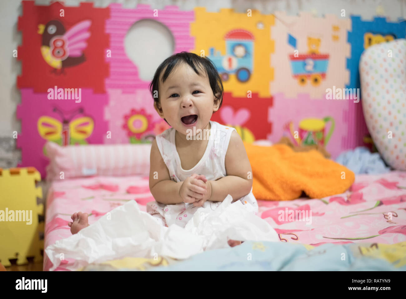 asia baby happy on the bed / baby child laughing face open your mouth and clap / beautiful baby girl expressive adorable happy cute smiling infant col Stock Photo
