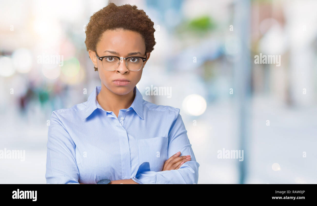 Young beautiful african american business woman over isolated background skeptic and nervous, disapproving expression on face with crossed arms. Negat Stock Photo