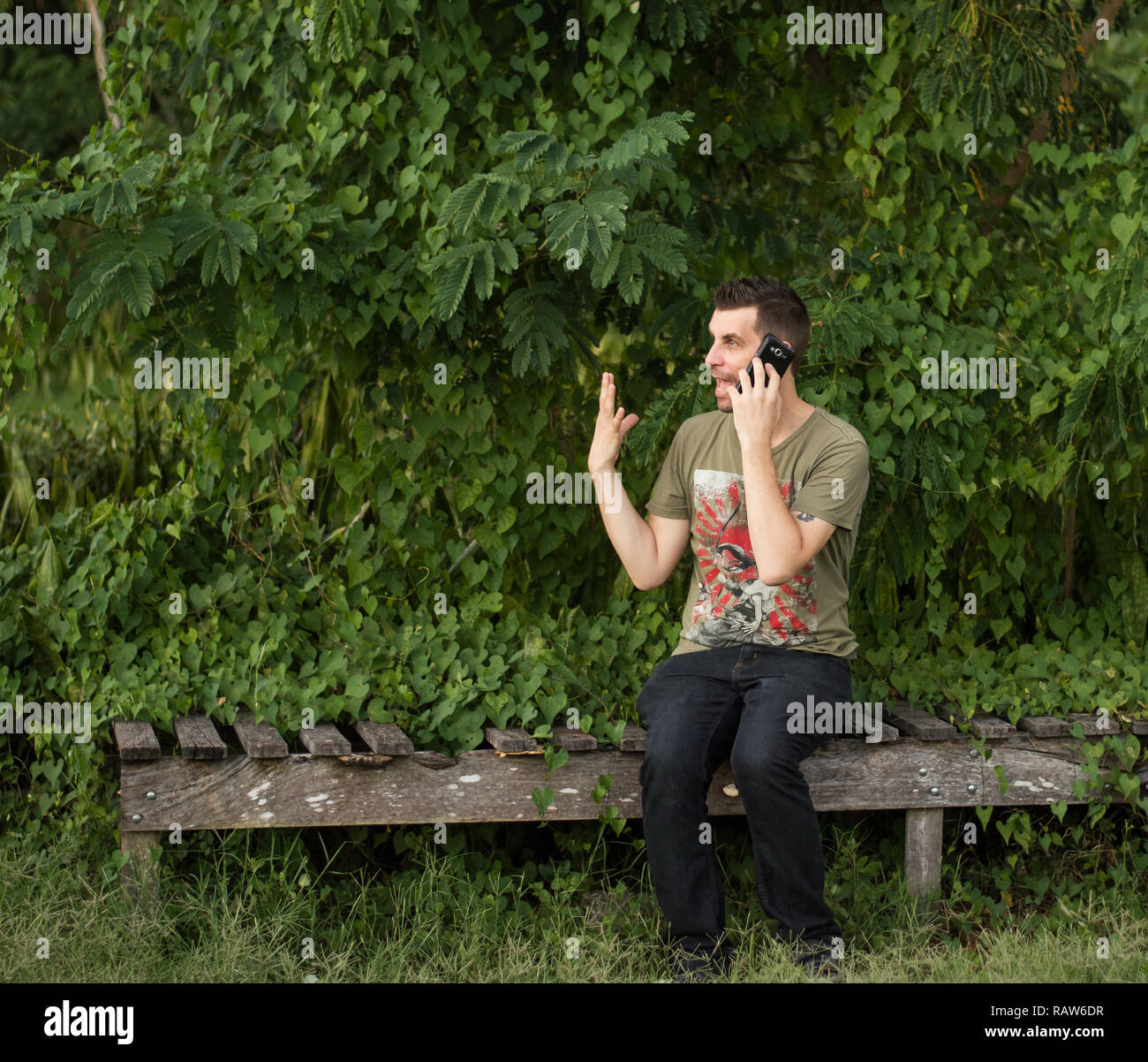 Angry middle aged man on mobile phone while in nature. Stock Photo