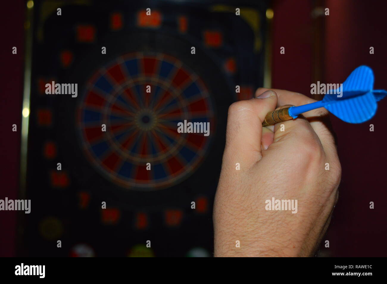 Game of darts, person playing darts hitting bulls eye Stock Photo