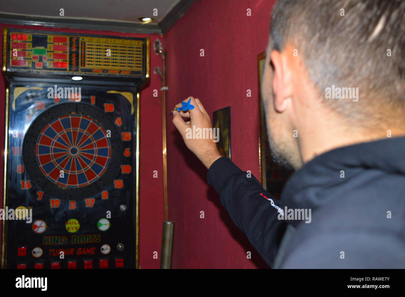 Game of darts, person playing darts hitting bulls eye Stock Photo
