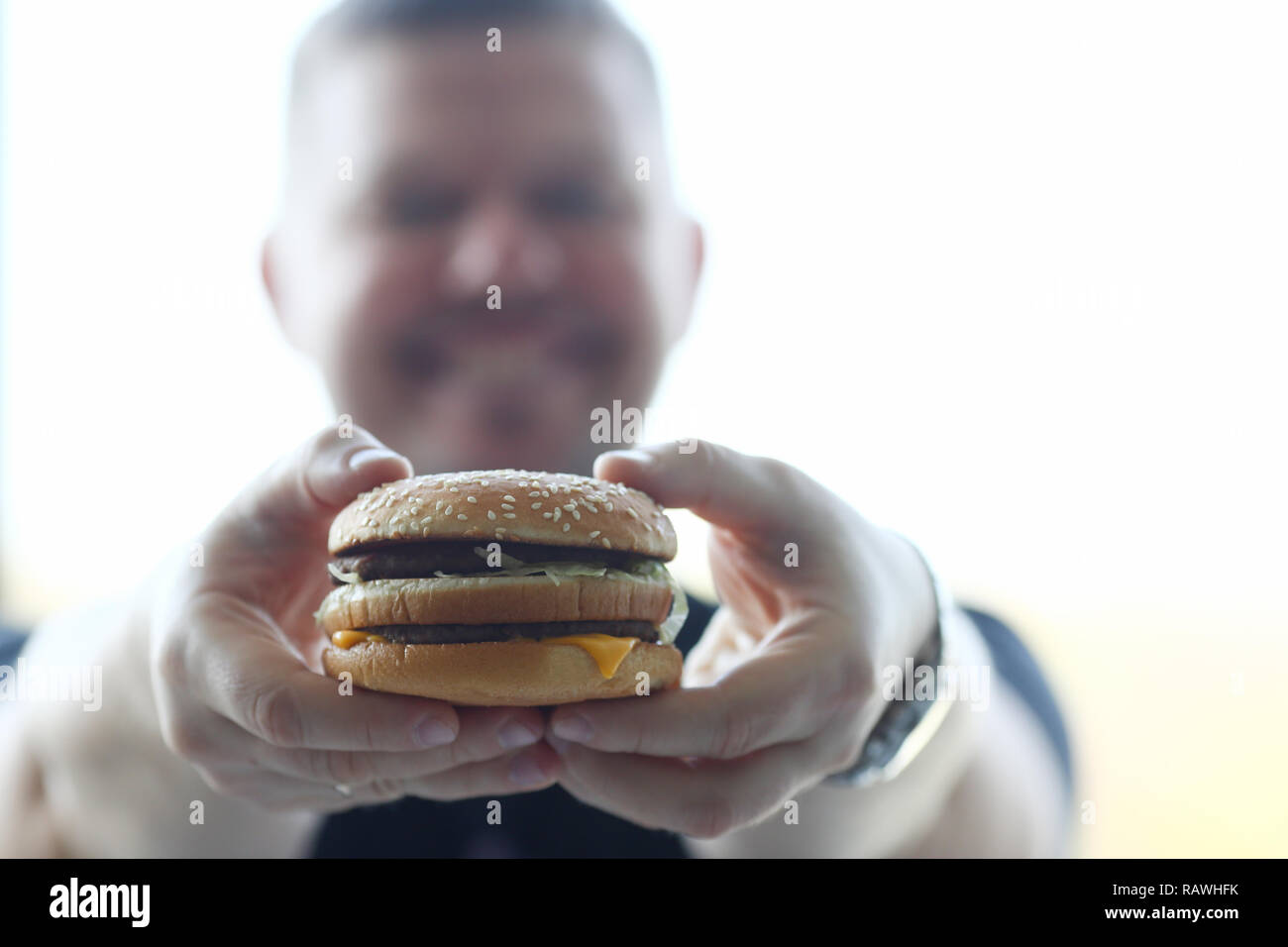 Satisfied young man holding a hamburger Stock Photo