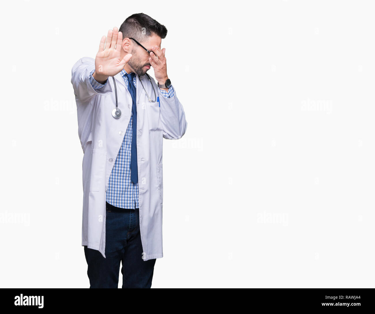Handsome young doctor man over isolated background covering eyes with hands and doing stop gesture with sad and fear expression. Embarrassed and negat Stock Photo